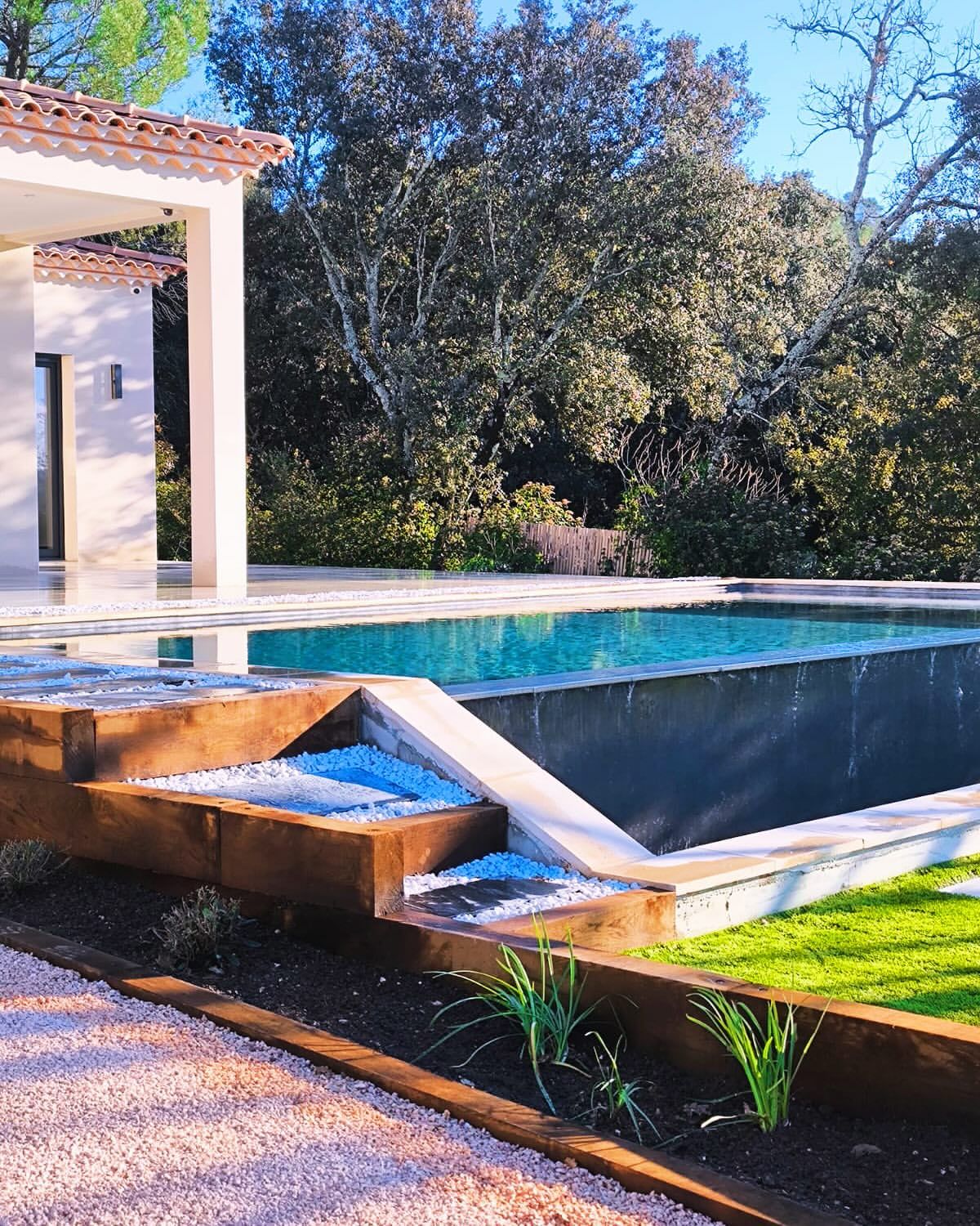 Piscine à débordement et terrasse en pierre, réalisation Vert Beau Bois