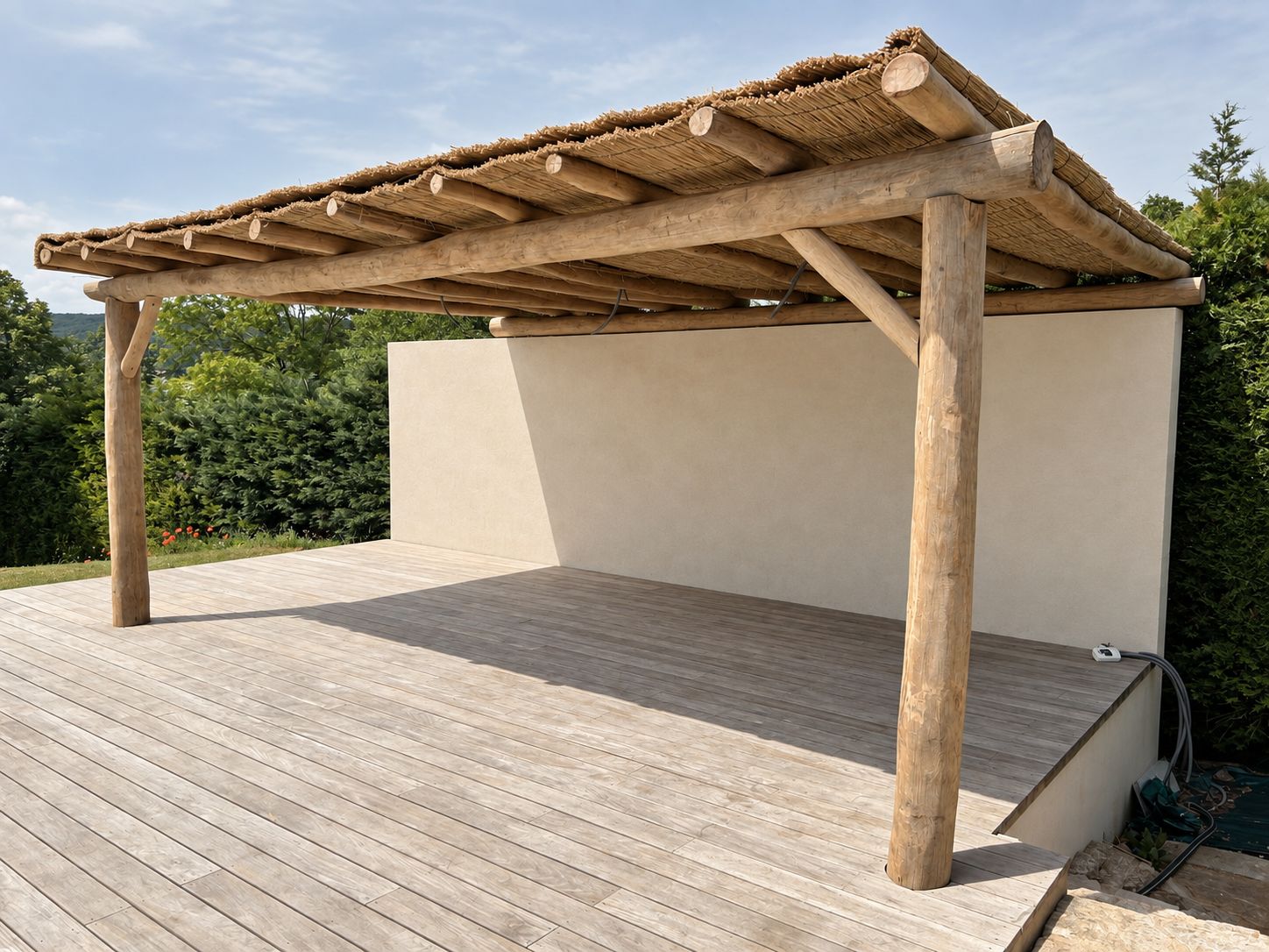 Pergola en bois flotté avec toiture en chaume, vue sur le jardin
