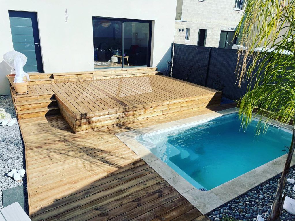 Grande terrasse en bois à plusieurs niveaux autour d'une piscine